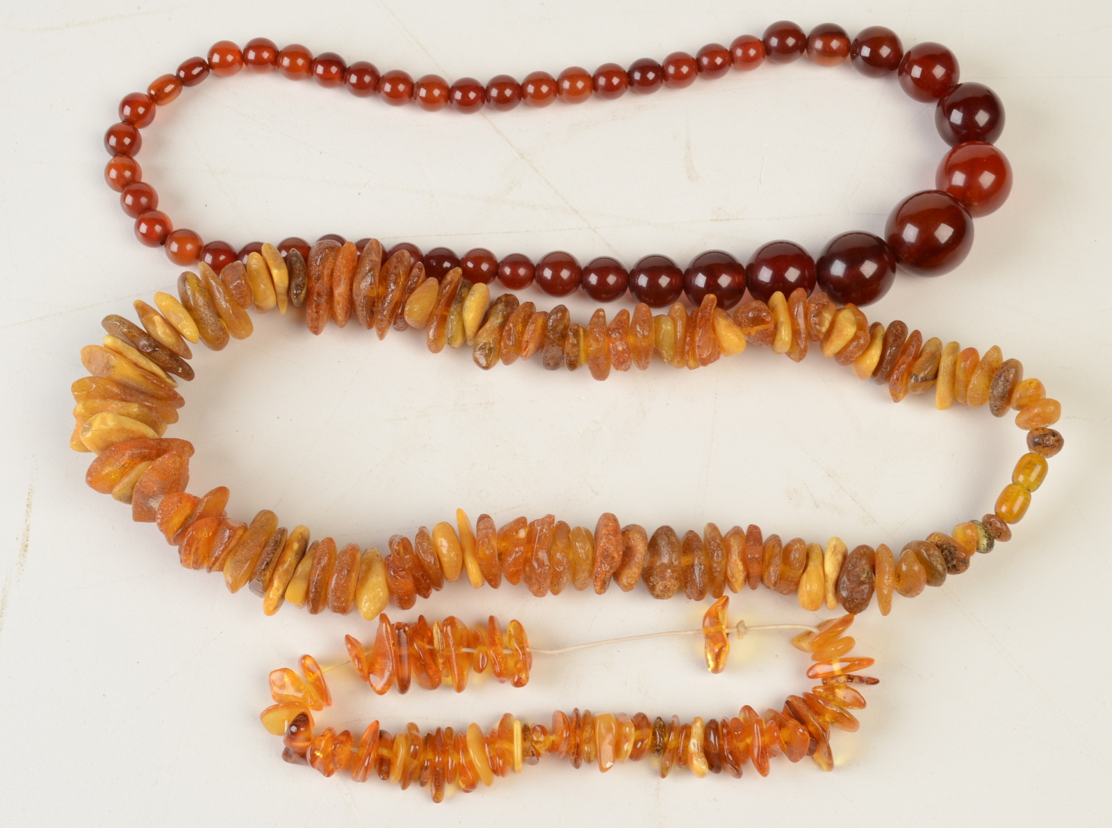 Two amber necklaces and an amber style necklace.