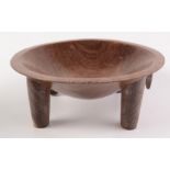 A Fijian carved hardwood kava bowl of circular form on four peg feet, height 12cm, diameter 31.25cm.