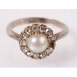 A 9ct white gold ring with a pearl and diamond cluster.