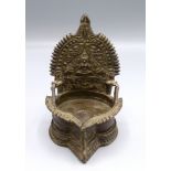 An Indian bronze oil burner decorated with a seated goddess flanked by elephants, height 13.5cm.