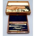 A boxed set of bone and ebonised dominoes and a mahogany cased set of drawing instruments.