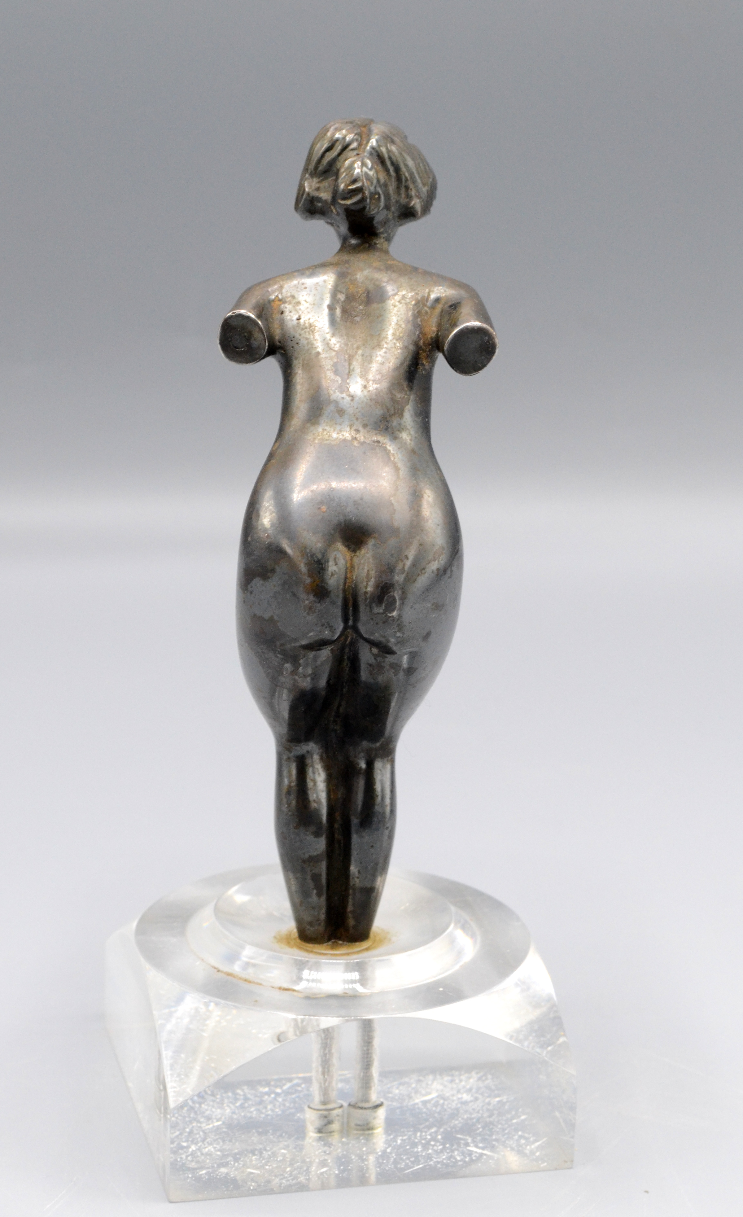 A white metal car mascot in the form of a naked lady mounted on a perspex base, height 16cm. - Image 2 of 2