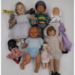 A collection of nine dolls including composition celluloid and plastic, porcelain head.