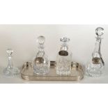 Four cut glass decanters and stoppers, with three silver plated labels entitled Scotch,