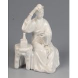 A Chinese blanc de chine figure of a seated lady arranging a flower in her hair, height 16.