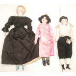 Three porcelain head dolls, two with shoulder plate, each in vintage style clothing.