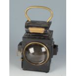 A black tin plate railway lantern with a brass handle,