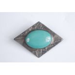 An Arts and Crafts pewter mounted brooch with a central Ruskin style cabochon.