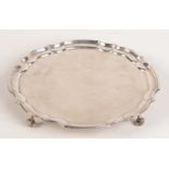 A post war silver tray on four scrolling legs, dimeter 25cm. 15.6oz.