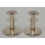 A pair of plain filled silver candlesticks with circular bases, height 12.