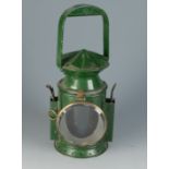 A railway lantern, the handle twisting to operate the red, green and clear glasses,