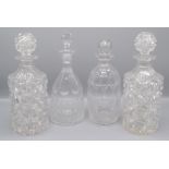 A pair of cut glass cylindrical decanters, height 25cm and two other decanters.