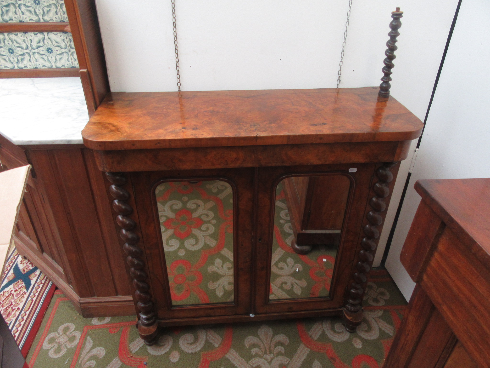 A Victorian burr walnut veneered chiffonier with a pair of arched mirrored doors flanked by spiral