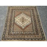 A Turkish carpet, the brown field with an ivory stepped medallion within multiple borders,