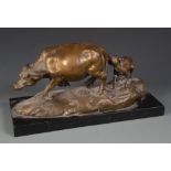 A bronze group of an oxen and calf, on a rectangular black slate base, height 15cm, width 29cm.