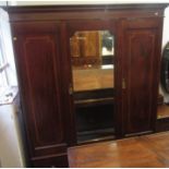 An Edwardian inlaid mahogany wardrobe with a central mirrored door flanked by a pair of blind doors