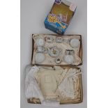 A ceramic child's tea service and a few items of dolls clothing,