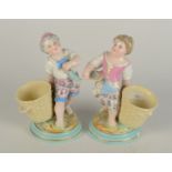 A pair of continental porcelain figures of girls with baskets, late 19th/early 20th century,