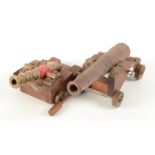 A bronze and part red painted model of a canon, barrel length 15cm,