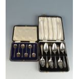 A set of six silver grapefruit spoons, cased, and a set of six Puritan pattern coffee spoons, cased.