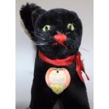 A Steiff black cat in frightened pose, paper label to neck, full height 12".