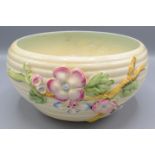 A Clarice Cliff bowl, the ribbed body decorated with a floral and leafy branch, diameter 20cm.
