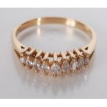 An 18ct gold contemporary ring set with a row of nine graduated navette cut diamonds.