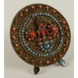 A Tibetan gilt metal circular stand, set with pink and blue stones,