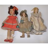Three firmly filled fabric dolls each with painted and moulded faces, the larger length 17".