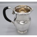 A Georg Jensen silver jug the ebony handle with grape finials beneath the beaded inward curved rim