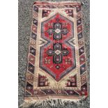 A Turkish rug, the ivory field with two polychrome lobed medallions,