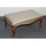 A Victorian walnut stool, the padded seat on cabriole supports, height 40cm, width 98cm, depth 56cm.