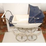 A 1960s Silver Cross pram in blue and white with original handbag hanging from the handle bars,