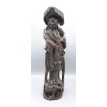 A Chinese carved wood figure of a fisherman, 19th century, standing on a plinth base,