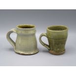 Two Mike Dodd Studio Pottery glazed mugs, heights 9cm.