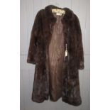 A dark brown, three quarter length mink coat by The Norwich Fur Co., size 10-12.