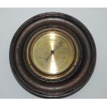 An oak cased wall barometer by Dollond, London, with a circular gilt metal dial, diameter 25.5cm.