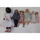A group of six dolls including a small doll with painted porcelain head and a 1950s/early 1960s