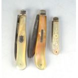 Three fruit knives with folding silver blades.