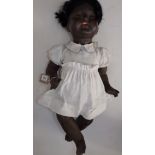 An all composition black baby doll, the head with sleep eyes, open mouth, teeth and tongue,