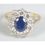 A sapphire and diamond oval cluster 18ct gold ring.