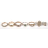 A 14ct gold band 6.8g, an 18ct gold ring and five other gold rings.