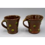Two Paul Young Studio Pottery brown glazed mugs, each decorated with green glazed roundels,