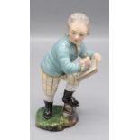 A Hochst porcelain figure of a young scribe, height 12.5cm.