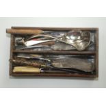 Miscellaneous silver plated cutlery, including a soup ladle, length 27cm, in a wooden cutlery tray.