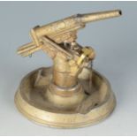 A die cast ashtray mounted with a model field gun hinged to reveal a table lighter.