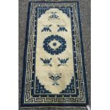 A Chinese rug, the ivory field with a blue circular central medallion,