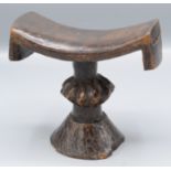 An Ethiopian hardwood head rest, the column with a carved centre on a flared foot, height 12.
