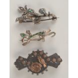 A Victorian silver and gold Aesthetic Movement brooch and two other silver brooches.