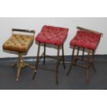 Three music stools, each with a button upholstered padded seat, height of largest 61.5cm.